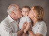 Due nonni che baciano il nipote di nove mesi durante servizio fotografico in studio di Famiglia