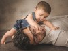 Bambino che gioca con papà durante servizio fotografico in studio di famiglia